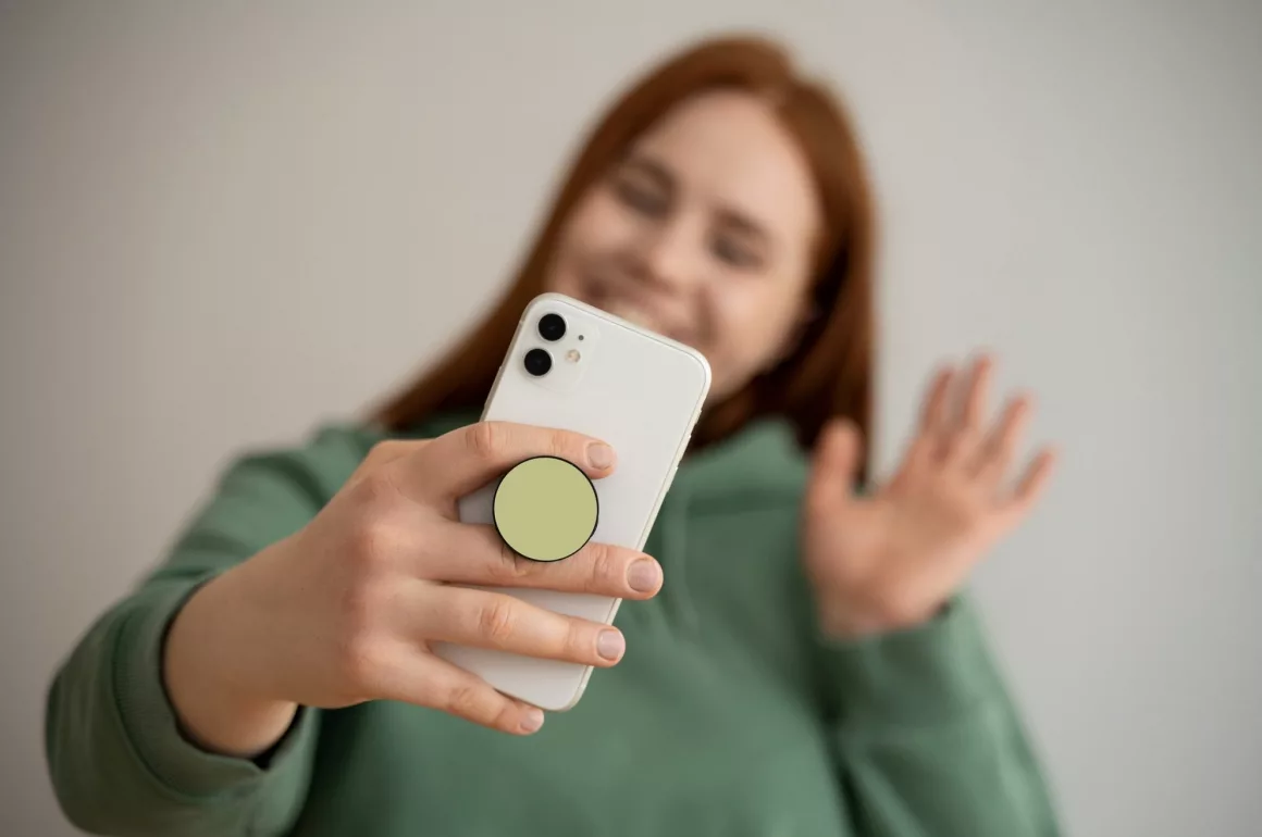 Femme souriante utilisant smartphone pour vidéo appel.