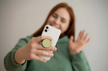 Femme souriante utilisant smartphone pour vidéo appel.