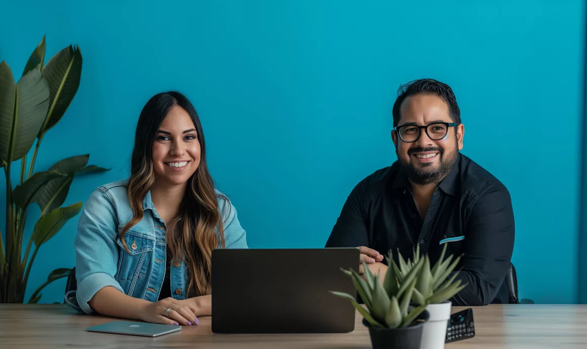 Deux personnes souriantes devant un ordinateur.