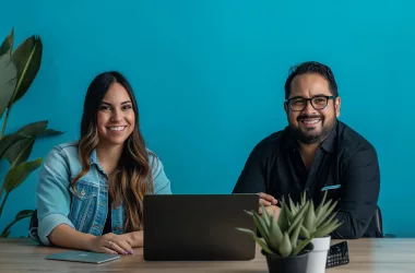 Deux personnes souriantes devant un ordinateur.