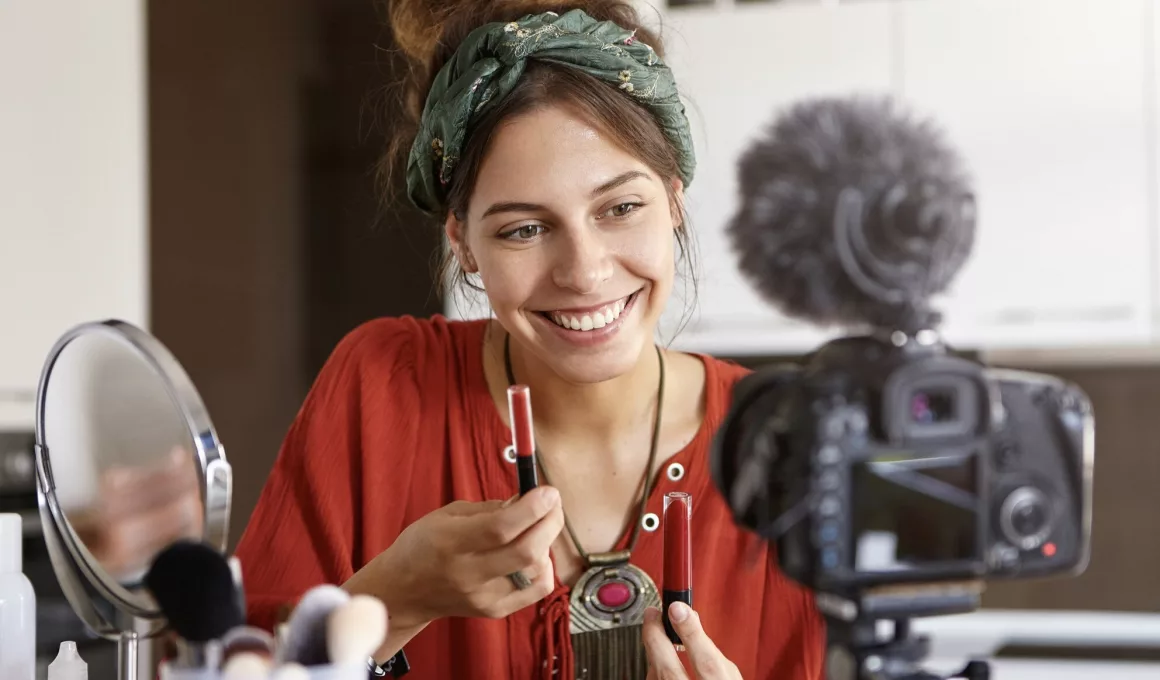 Femme souriante faisant un tutoriel maquillage.