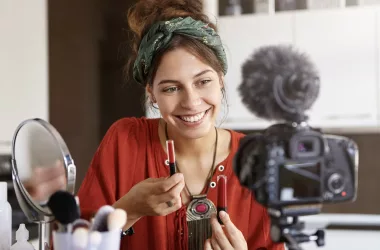 Femme souriante faisant un tutoriel maquillage.