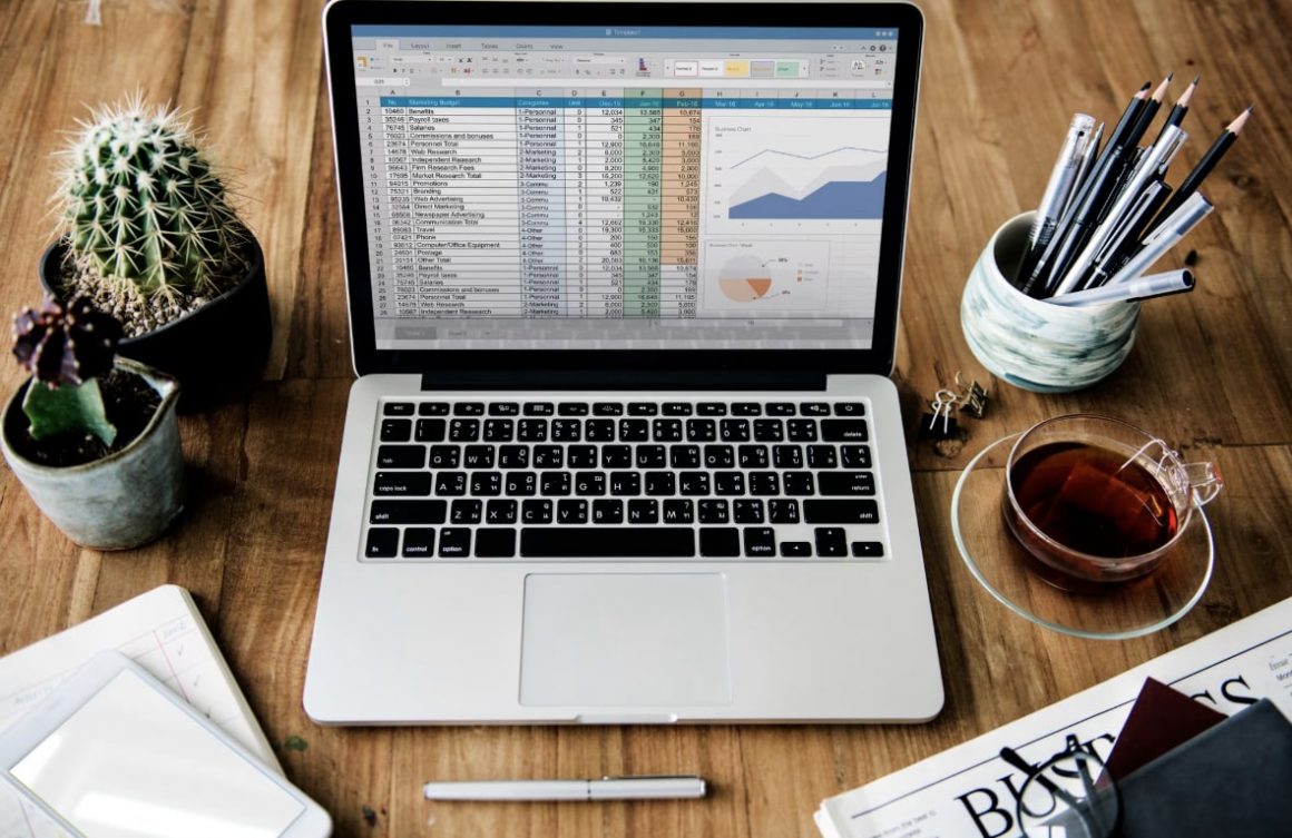 Ordinateur portable avec tableur ouvert sur bureau.