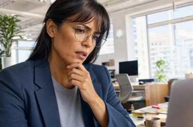 Femme concentrée travaillant sur ordinateur au bureau