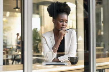 Femme réfléchissant dans un café avec tablette
