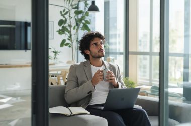 Homme pensif avec ordinateur portable au bureau