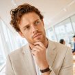 Consultant marketing en réflexion dans une salle de réunion vitrée — choisir son agence Meta Ads SaaS B2B
