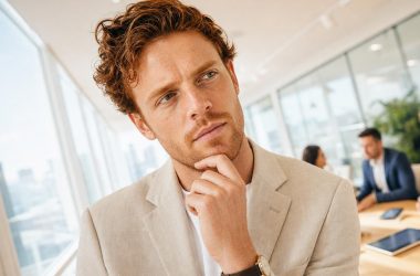 Consultant marketing en réflexion dans une salle de réunion vitrée — choisir son agence Meta Ads SaaS B2B