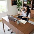 Femme réfléchissant devant un ordinateur portable au bureau